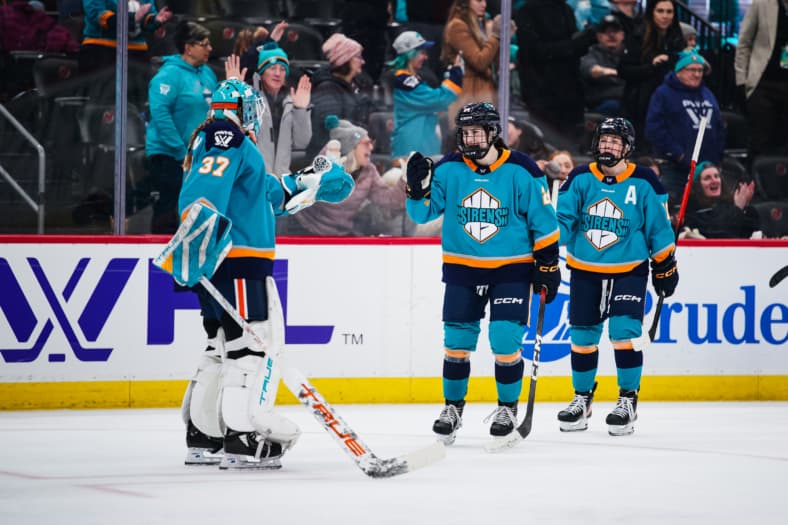New York Sirens rookie Anne Cherkowski fist bumbs Callie Shanahan after scoring a goal against the Ottawa Charge.