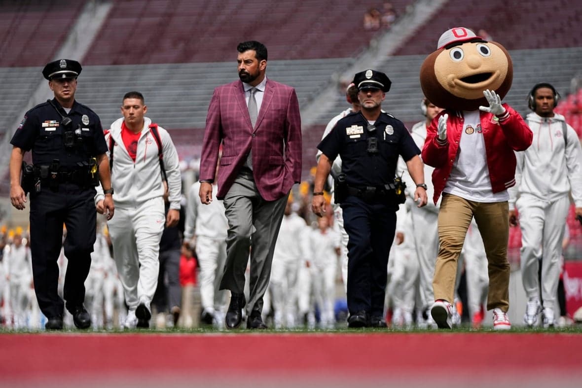 Ohio State Buckeyes head coach Ryan Day and mascot Brutus walk across the field as the team arrives prior to the NCAA footba…