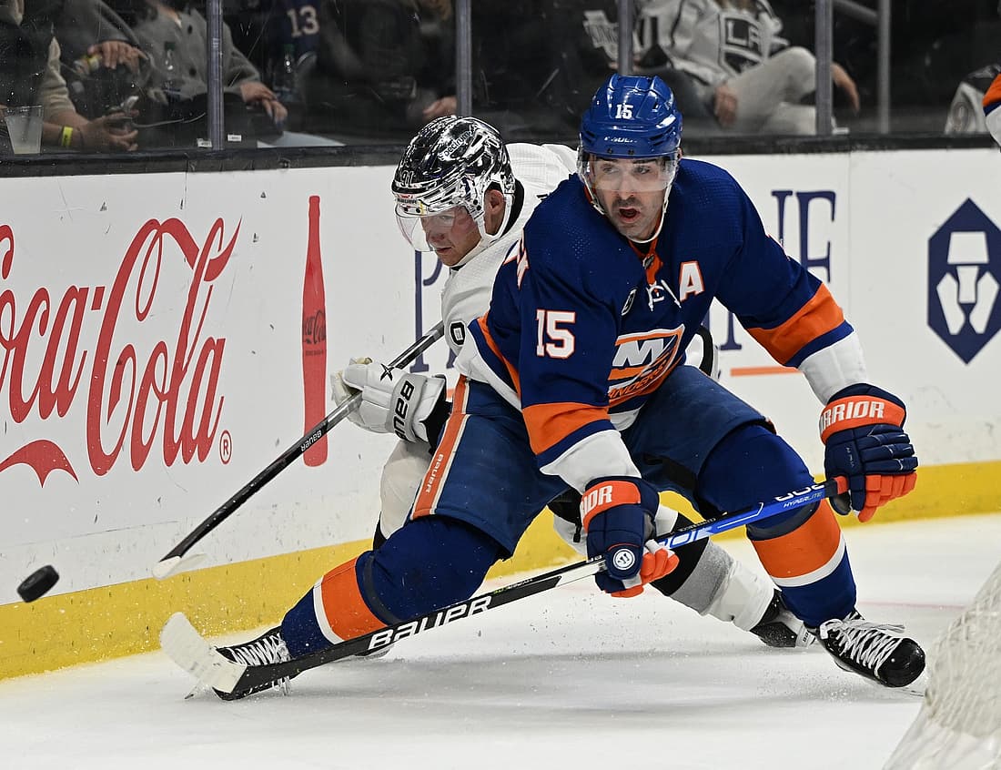 Feb 26, 2022; Los Angeles, California, USA; New York Islanders right wing Cal Clutterbuck (15) and Los Angeles Kings right wing Carl Grundstrom (91) battle for the puck in the third period at Crypto.com Arena. Mandatory Credit: Jayne Kamin-Oncea-USA TODAY Sports