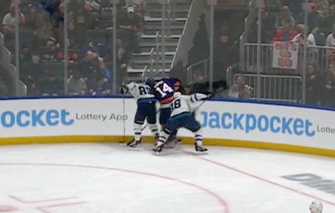 New York Islanders Bo Horvat pinning puck along boards.