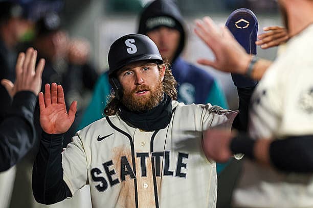 SEATTLE, WASHINGTON – MARCH 29: Brendan Donovan #33 of the Seattle Mariners celebrates in the dugout after scoring a run dur…