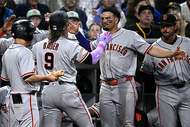 SAN DIEGO, CALIFORNIA – MARCH 30: Harrison Bader #9 of the San Francisco Giants is congratulated at the dugout by Willy Adam…