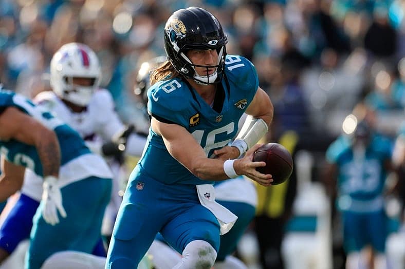 Jacksonville Jaguars quarterback Trevor Lawrence (16) looks to handoff during the fourth quarter of an NFL football AFC Wild