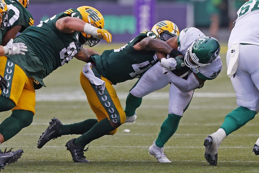 Jun 11, 2023; Edmonton, Alberta, CAN; Saskatchewan Roughriders running back Frankie Hickson (20) is tackled by Edmonton Elks linebacker Myles Morgan (45) during the second half at Commonwealth Stadium. Mandatory Credit: Perry Nelson-USA TODAY Sports