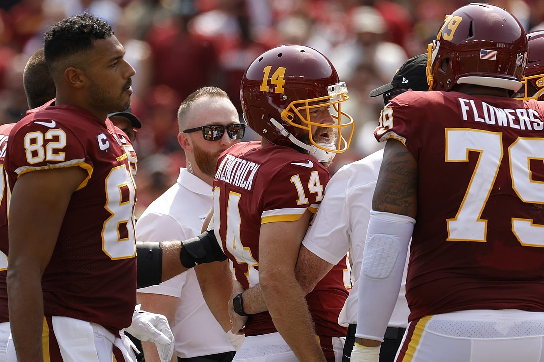 Sep 12, 2021; Landover, Maryland, USA; Washington Football Team quarterback Ryan Fitzpatrick (14) is helped off the field after being inured against the Los Angeles Chargers in the second quarter at FedExField. Mandatory Credit: Geoff Burke-USA TODAY Sports