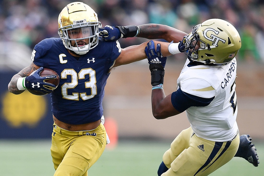 Nov 20, 2021; South Bend, Indiana, USA; Notre Dame Fighting Irish running back Kyren Williams (23) stiff arms Georgia Tech Yellow Jackets safey Tariq Carpenter (2) in the second quarter at Notre Dame Stadium. Mandatory Credit: Matt Cashore-USA TODAY Sports