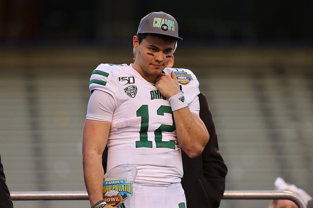 Jan 3, 2020; Boise, Idaho, USA; Ohio Bobcats quarterback Nathan Rourke (12) receives the Famous Idaho Potato Bowl most valuable player trophy after defeating the Nevada Wolf Pack at Albertsons Stadium. Ohio won 30-21. Mandatory Credit: Brian Losness-USA TODAY Sports