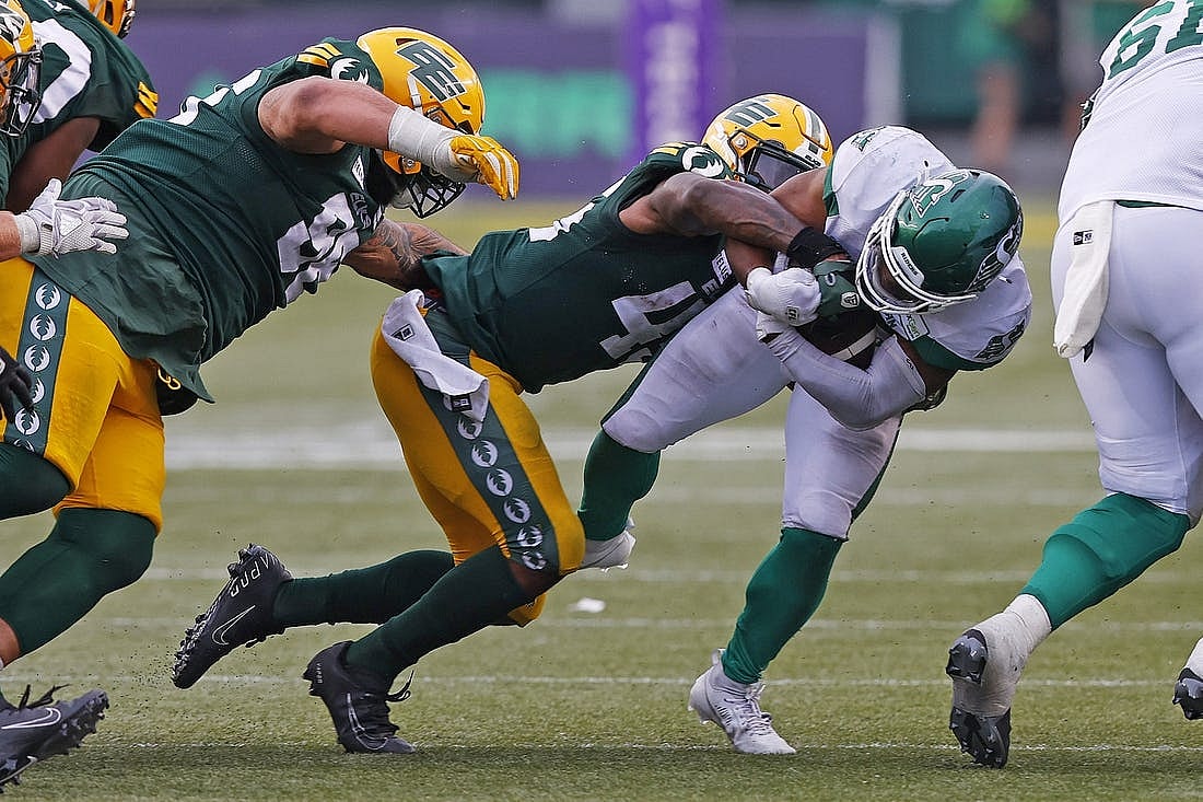 Jun 11, 2023; Edmonton, Alberta, CAN; Saskatchewan Roughriders running back Frankie Hickson (20) is tackled by Edmonton Elks linebacker Myles Morgan (45) during the second half at Commonwealth Stadium. Mandatory Credit: Perry Nelson-USA TODAY Sports