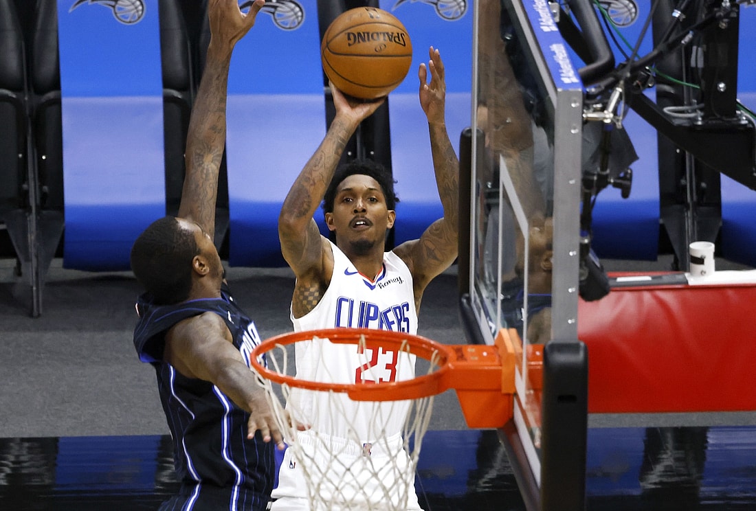 Jan 29, 2021; Orlando, Florida, USA; LA Clippers guard Lou Williams (23) shoots over Orlando Magic forward James Ennis III (11) during the first quarter at Amway Center. Mandatory Credit: Reinhold Matay-USA TODAY Sports