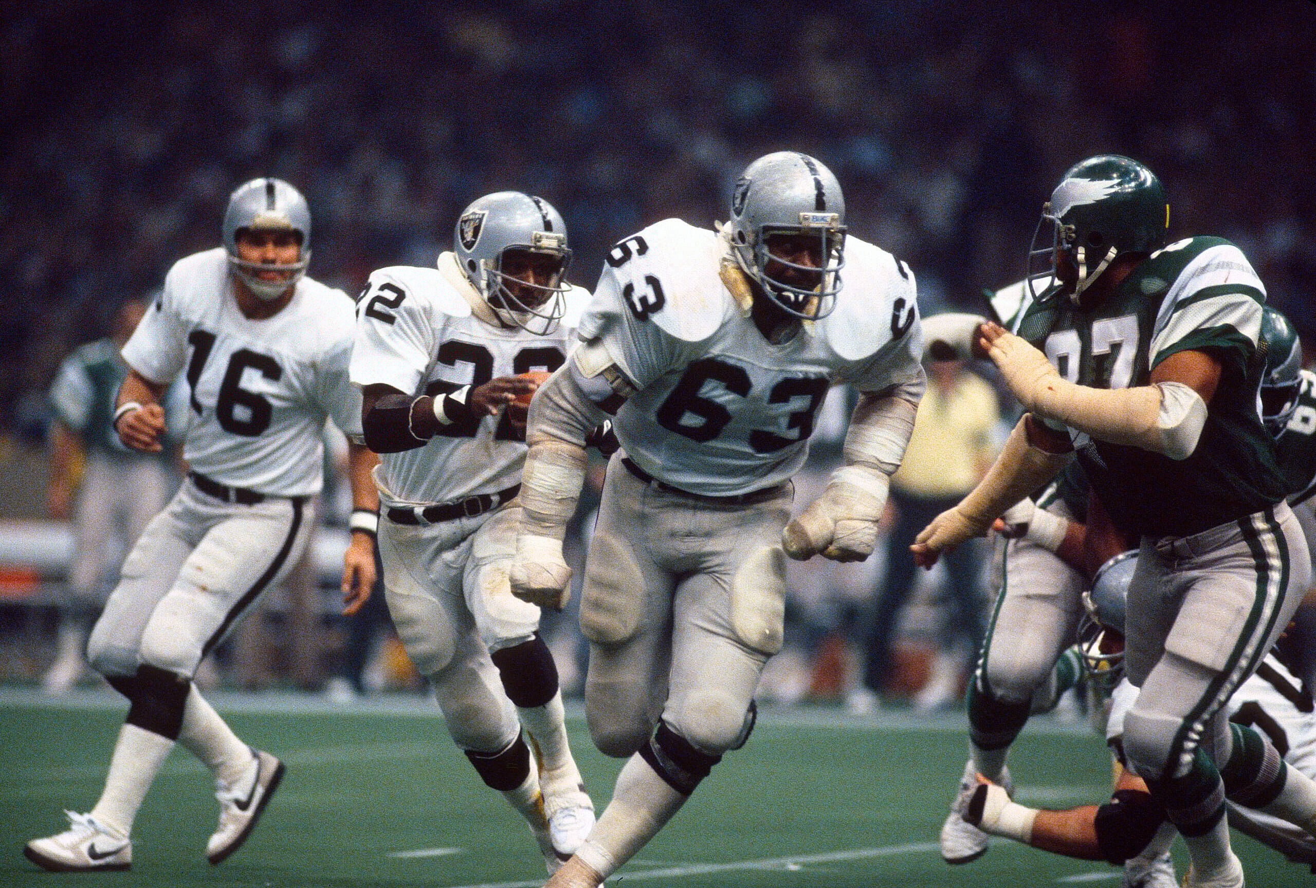 Oakland Raiders guard Gene Upshaw leads a run play