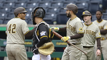 Apr 15, 2021; Pittsburgh, Pennsylvania, USA;  San Diego Padres third baseman Manny Machado (left) is congratulated by San Diego Padres first baseman Eric Hosmer (30) after hitting a two run home run as Pittsburgh Pirates catcher Jacob Stallings (middle) looks on during the first inning at PNC Park. Mandatory Credit: Charles LeClaire-USA TODAY Sports