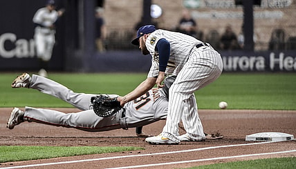 Aug 6, 2021; Milwaukee, Wisconsin, USA; Milwaukee Brewers first baseman Rowdy Tellez (11) cannot field the ball on a throwing error by pitcher Corbin Burnes (not pictured) while trying to pick off San Francisco Giants center fielder LaMonte Wade Jr (31) in the first inning at American Family Field. Mandatory Credit: Benny Sieu-USA TODAY Sports