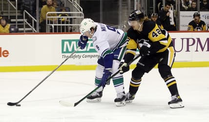 Nov 24, 2021; Pittsburgh, Pennsylvania, USA;  Vancouver Canucks center J.T. Miller (9) moves the puck against Pittsburgh Penguins right wing Kasperi Kapanen (42) during the first period at PPG Paints Arena. Mandatory Credit: Charles LeClaire-USA TODAY Sports