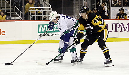 Nov 24, 2021; Pittsburgh, Pennsylvania, USA;  Vancouver Canucks center J.T. Miller (9) moves the puck against Pittsburgh Penguins right wing Kasperi Kapanen (42) during the first period at PPG Paints Arena. Mandatory Credit: Charles LeClaire-USA TODAY Sports