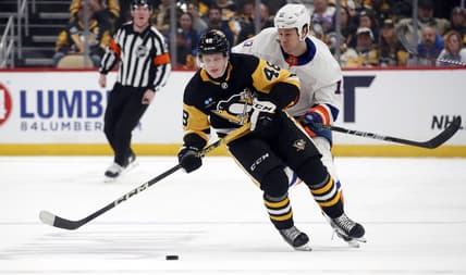 Dec 31, 2023; Pittsburgh, Pennsylvania, USA;  Pittsburgh Penguins right wing Valtteri Puustinen (48) moves the puck ahead of New York Islanders left wing Matt Martin (17) during the first period at PPG Paints Arena. Mandatory Credit: Charles LeClaire-USA TODAY Sports