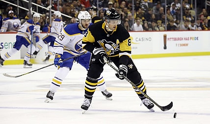 Nov 16, 2021; Pittsburgh, Pennsylvania, USA;  Pittsburgh Penguins defenseman Brian Dumoulin (8) handles the puck  as Buffalo Sabres left wing Vinnie Hinostroza (29) chases during the first period at PPG Paints Arena. Mandatory Credit: Charles LeClaire-USA TODAY Sports