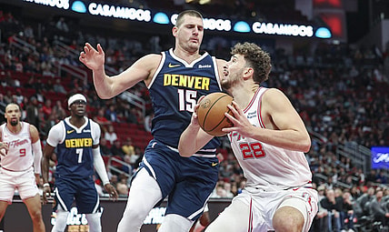 Nov 24, 2023; Houston, Texas, USA; Houston Rockets center Alperen Sengun (28) drives with the ball as Denver Nuggets center Nikola Jokic (15) defends during the first quarter at Toyota Center. Mandatory Credit: Troy Taormina-USA TODAY Sports