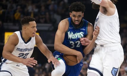 Apr 16, 2022; Memphis, Tennessee, USA; Minnesota Timberwolves center Karl-Anthony Towns (32) keeps control of the ball as he   s guarded by Memphis Grizzlies guard Desmond Bane (22) and Memphis Grizzlies center Steven Adams (4) during the first half of game one of the first round for the 2022 NBA playoffs at FedExForum. Mandatory Credit: Christine Tannous-USA TODAY Sports