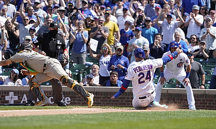 Jun 2, 2021; Chicago, Illinois, USA; Chicago Cubs left fielder Joc Pederson (24 scores as San Diego Padres catcher Webster Rivas (48) takes a late throw during the fifth inning )at Wrigley Field. Mandatory Credit: David Banks-USA TODAY Sports