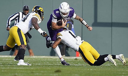 Nov 4, 2023; Chicago, Illinois, USA; Iowa Hawkeyes defensive back Xavier Nwankpa (1) tackles Northwestern Wildcats quarterback Brendan Sullivan (6) during the first half at Wrigley Field. Mandatory Credit: David Banks-USA TODAY Sports
