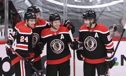 Feb 28, 2021; Chicago, Illinois, USA; Chicago Blackhawks left wing Alex DeBrincat (center)  celebrates his goal against the Detroit Red Wings during the third period at United Center. Mandatory Credit: David Banks-USA TODAY Sports