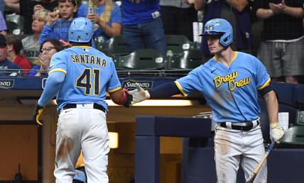 Aug 25, 2023; Milwaukee, Wisconsin, USA; Milwaukee Brewers first baseman Carlos Santana (41) scores a run against the San Diego Padres and is congratulated by Milwaukee Brewers left fielder Mark Canha (21) in the seventh inning at American Family Field. Mandatory Credit: Michael McLoone-USA TODAY Sports