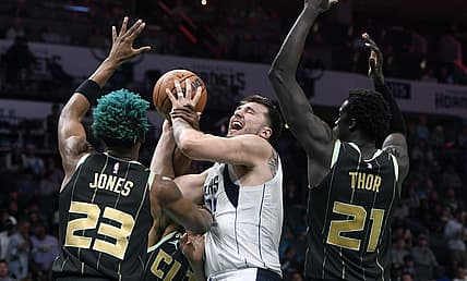 Mar 26, 2023; Charlotte, North Carolina, USA;  Dallas Mavericks guard Luka Doncic (77) shoots as he is defended by Charlotte Hornets forward center Kai Jones (23) and forward JT Thor (21) during the first half at the Spectrum Center. Mandatory Credit: Sam Sharpe-USA TODAY Sports