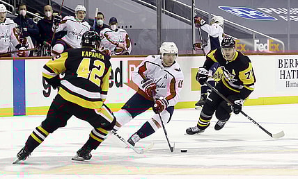 Feb 14, 2021; Pittsburgh, Pennsylvania, USA;  Washington Capitals center Nicklas Backstrom (19) carries the puck between Pittsburgh Penguins right wing Kasperi Kapanen (42) and center Evgeni Malkin (71) during the first period at PPG Paints Arena. Mandatory Credit: Charles LeClaire-USA TODAY Sports