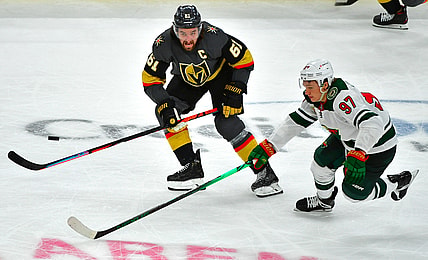 May 16, 2021; Las Vegas, Nevada, USA; Vegas Golden Knights right wing Mark Stone (61) tips the puck away from Minnesota Wild left wing Kirill Kaprizov (97) during the third period of game one of the first round of the 2021 Stanley Cup Playoffs at T-Mobile Arena. Mandatory Credit: Stephen R. Sylvanie-USA TODAY Sports
