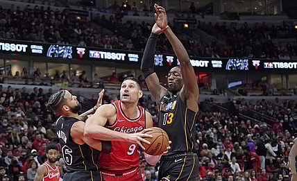 Nov 27, 2021; Chicago, Illinois, USA; Chicago Bulls center Nikola Vucevic (9) is defended by Miami Heat forward Caleb Martin (16) and center Bam Adebayo (13) during the first half at United Center. Mandatory Credit: David Banks-USA TODAY Sports