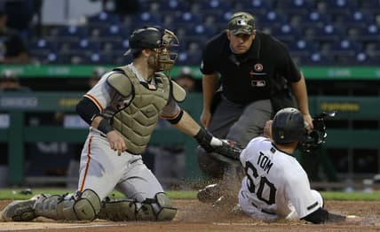 May 15, 2021; Pittsburgh, Pennsylvania, USA;  San Francisco Giants catcher Curt Casali (2) tags Pittsburgh Pirates pinch hitter Ka'ai Tom (60) out at home attempting to score as umpire Mark Ripperger (90)looks on during the fifth inning at PNC Park. Mandatory Credit: Charles LeClaire-USA TODAY Sports