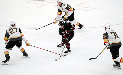 Jan 22, 2021; Glendale, Arizona, USA; Arizona Coyotes right wing Conor Garland (83) skates against Vegas Golden Knights defenseman Shea Theodore (27) and defenseman Alex Pietrangelo (7) and right wing Ryan Reaves (75) during the second period at Gila River Arena. Mandatory Credit: Joe Camporeale-USA TODAY Sports