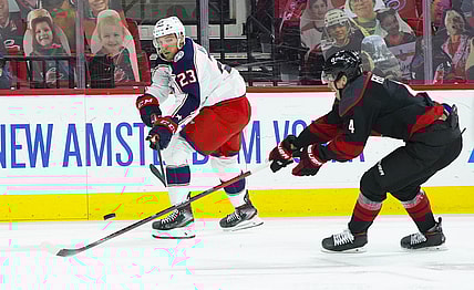 Mar 18, 2021; Raleigh, North Carolina, USA;  Columbus Blue Jackets Stefan Matteau (23) shoots against Carolina Hurricanes defenseman Haydn Fleury (4) during the first period at PNC Arena. Mandatory Credit: James Guillory-USA TODAY Sports