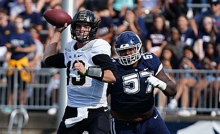 Sep 11, 2021; East Hartford, Connecticut, USA;  Purdue Boilermakers quarterback Jack Plummer (13) throws a pass under pressure from Connecticut Huskies defensive lineman Travis Jones (57) in the first half at Rentschler Field at Pratt & Whitney Stadium. Mandatory Credit: David Butler II-USA TODAY Sports