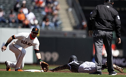 Apr 10, 2021; San Francisco, California, USA; Colorado Rockies fielder Garrett Hampson (1) is caught stealing second base by San Francisco Giants third baseman Evan Longoria (L) as umpire Pat Hoberg (R) looks on during the first inning at Oracle Park. Mandatory Credit: D. Ross Cameron-USA TODAY Sports