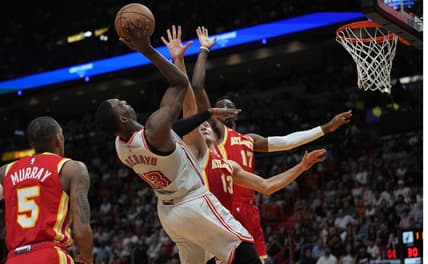 Mar 4, 2023; Miami, Florida, USA; Miami Heat center Bam Adebayo (13) takes an off balance shot as Atlanta Hawks guard Bogdan Bogdanovic (13) defends in the first half at Miami-Dade Arena. Mandatory Credit: Jim Rassol-USA TODAY Sports