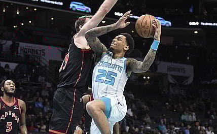 Feb 7, 2024; Charlotte, North Carolina, USA; Charlotte Hornets forward center P.J. Washington Jr. (25) drives in past Toronto Raptors center Jakob Poeltl (19) during the first half at the Spectrum Center. Mandatory Credit: Sam Sharpe-USA TODAY Sports