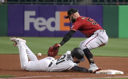 Aug 25, 2021; Pittsburgh, Pennsylvania, USA;  Pittsburgh Pirates second baseman Michael Chavis (31) dives back safely to first base as Arizona Diamondbacks first baseman Christian Walker (53) takes a pick-off attempt how during the fifth inning at PNC Park. Mandatory Credit: Charles LeClaire-USA TODAY Sports