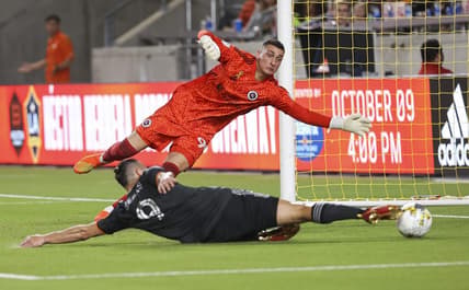 Sep 13, 2022; Houston, Texas, USA; New England Revolution goalkeeper Djordje Petrovic (99) leaps to make a save as Houston Dynamo FC forward Sebastian Ferreira (9) attempts to score during the second half at PNC Stadium. Mandatory Credit: Troy Taormina-USA TODAY Sports