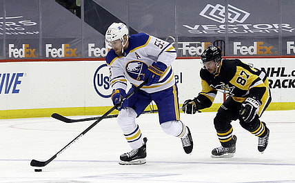 May 8, 2021; Pittsburgh, Pennsylvania, USA;  Buffalo Sabres defenseman Rasmus Ristolainen (55) skates up ice with the puck as Pittsburgh Penguins center Sidney Crosby (87) chases during the first period at PPG Paints Arena. Mandatory Credit: Charles LeClaire-USA TODAY Sports