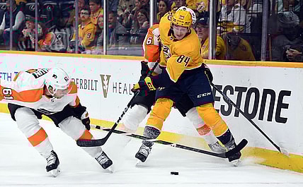 Oct 22, 2022; Nashville, Tennessee, USA; Nashville Predators left wing Tanner Jeannot (84) battles for the puck against Philadelphia Flyers defenseman Justin Braun (61) and defenseman Travis Sanheim (6) during the third period at Bridgestone Arena. Mandatory Credit: Christopher Hanewinckel-USA TODAY Sports