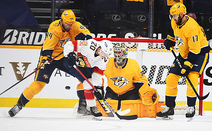 Apr 27, 2021; Nashville, Tennessee, USA; Nashville Predators goaltender Juuse Saros (74) makes a save with traffic from Florida Panthers center Aleksi Heponiemi (20) Florida Panthers defenseman Kevin Connauton (44) and Nashville Predators defenseman Ben Harpur (17) during the first period at Bridgestone Arena. Mandatory Credit: Christopher Hanewinckel-USA TODAY Sports