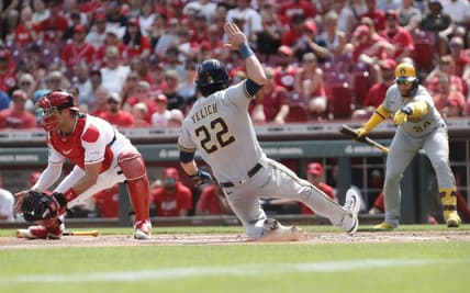 Jun 3, 2023; Cincinnati, Ohio, USA; Milwaukee Brewers left fielder Christian Yelich (22) scores against Cincinnati Reds catcher Curt Casali (12) during the first inning at Great American Ball Park. Mandatory Credit: David Kohl-USA TODAY Sports