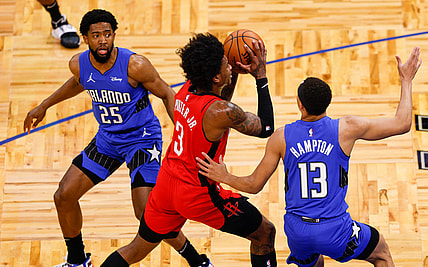 Apr 18, 2021; Orlando, Florida, USA;  Houston Rockets guard Kevin Porter Jr. (3) drives past Orlando Magic guard R.J. Hampton (13) and guard Chasson Randle (25) in the first quarter at Amway Center. Mandatory Credit: Nathan Ray Seebeck-USA TODAY Sports