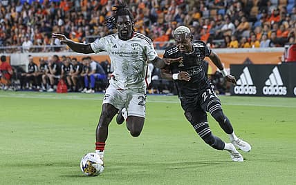 Sep 30, 2023; Houston, Texas, USA; FC Dallas midfielder Ema Twumasi (22) and Houston Dynamo FC forward Nelson Quinones (21) battle for the ball during the second half at Shell Energy Stadium. Mandatory Credit: Troy Taormina-USA TODAY Sports