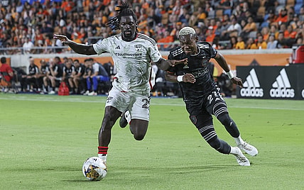 Sep 30, 2023; Houston, Texas, USA; FC Dallas midfielder Ema Twumasi (22) and Houston Dynamo FC forward Nelson Quinones (21) battle for the ball during the second half at Shell Energy Stadium. Mandatory Credit: Troy Taormina-USA TODAY Sports