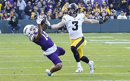 Nov 4, 2023; Chicago, Illinois, USA; Northwestern Wildcats wide receiver Cam Johnson (14) tries to catch a pass as Iowa Hawkeyes defensive back Cooper DeJean (3) defends during the first half at Wrigley Field. Mandatory Credit: David Banks-USA TODAY Sports