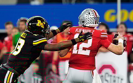 Dec 29, 2023; Arlington, Texas, USA; Ohio State Buckeyes quarterback Lincoln Kienholz (12) almost gets sacked by Missouri Tigers defensive back Daylan Carnell (13) before throwing the ball away in the second quarter during the Goodyear Cotton Bowl Classic at AT&T Stadium.