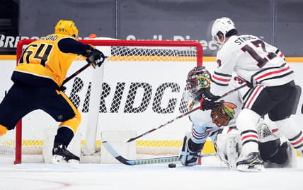 Jan 26, 2021; Nashville, Tennessee, USA; Chicago Blackhawks goaltender Malcolm Subban (30) covers a puck in the crease against  Nashville Predators center Mikael Granlund (64) during the second period at Bridgestone Arena. Mandatory Credit: Christopher Hanewinckel-USA TODAY Sports