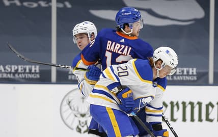 Feb 22, 2021; Uniondale, New York, USA; New York Islanders center Mathew Barzal (13) is checked by Buffalo Sabres defenseman Henri Jokiharju (10) and center Cody Eakin (20) during the second period at Nassau Veterans Memorial Coliseum. Mandatory Credit: Andy Marlin-USA TODAY Sports